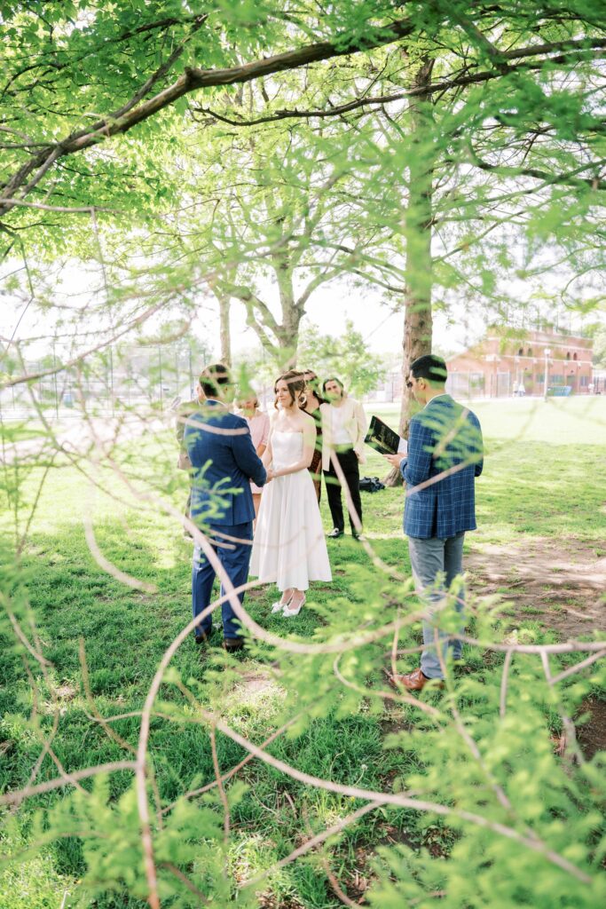 creative wedding ceremony shots; wedding ceremony photographed between tree branches