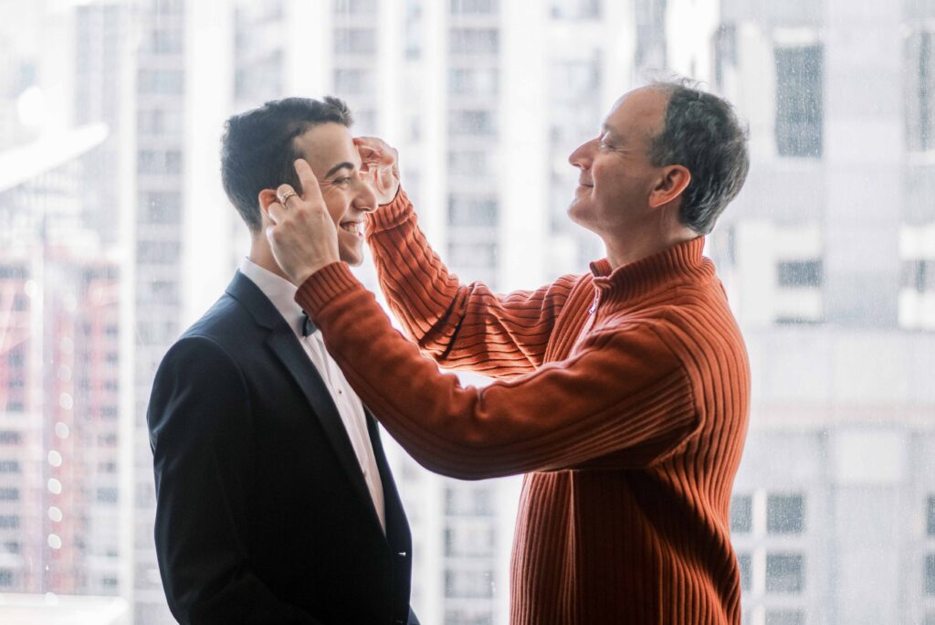 father helping groom get ready on wedding day