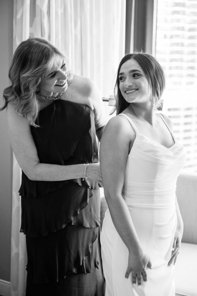 black and white photos of mother of the bride helping the bride get dressed