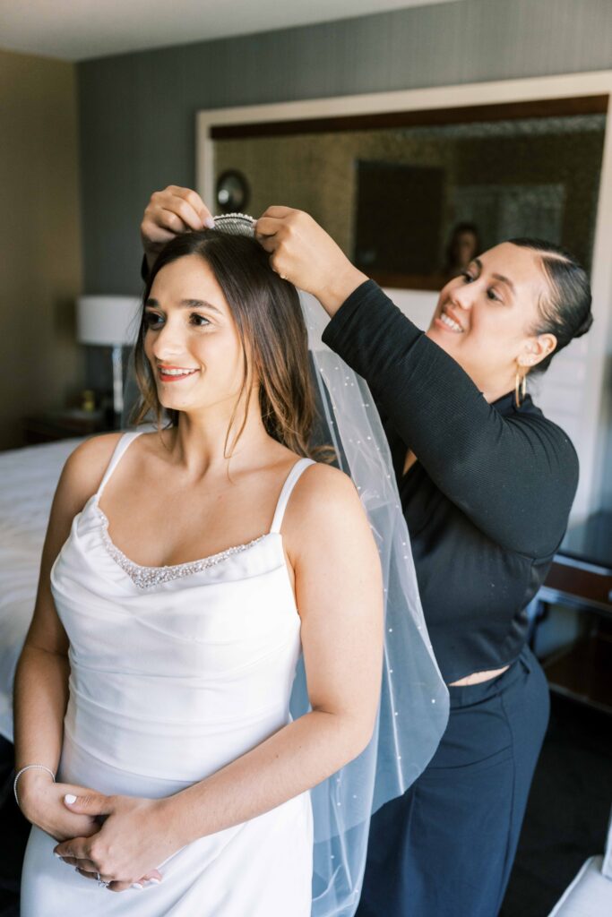 bridesmaids putting on bride's wedding veil