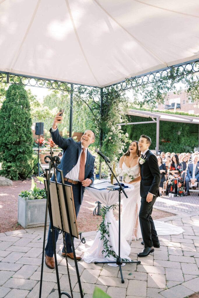funny wedding ceremony photos; bride and groom selfie during wedding ceremony